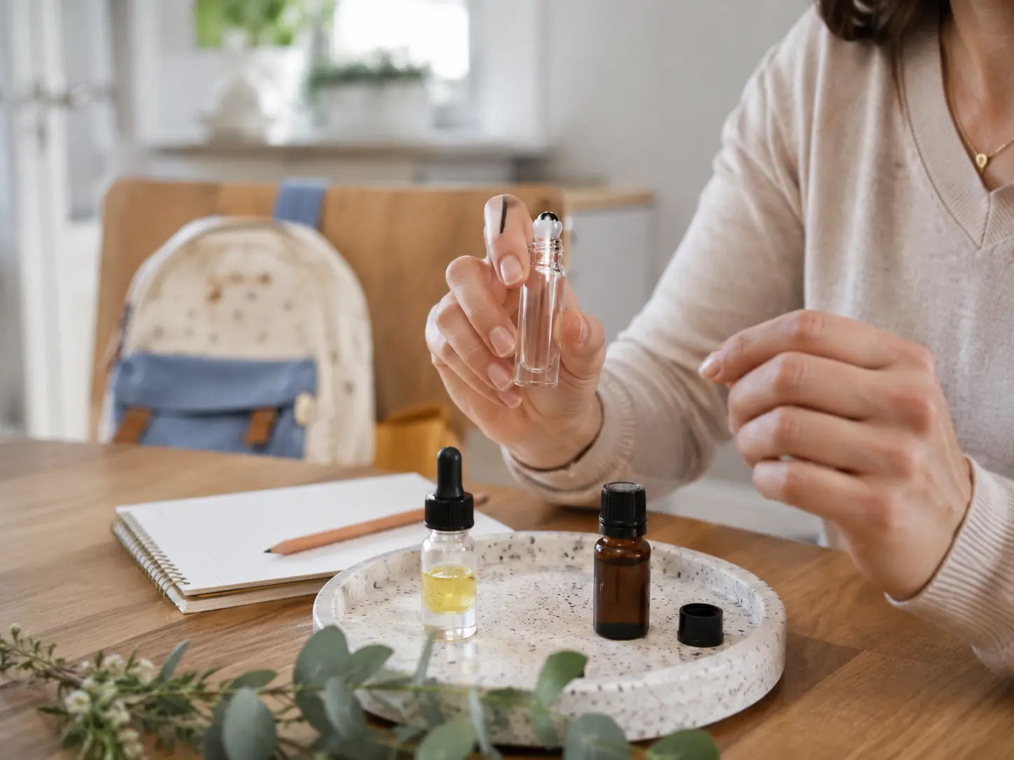 Szülő roll-on üveget tart bázisolajjal és jegyzettel gyerekek melletti döntéshez